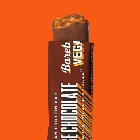 Guiltfree wegański baton proteinowy Barebells o smaku czekolady z pomarańczą, nadgryziony, z widocznym wnętrzem.