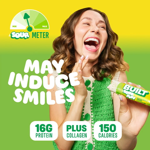 Guiltfree baton białkowy Built Sour Puff Green Apple Crush z piankowym wnętrzem i kwaśną posypką w rękach uśmiechniętej kobiety