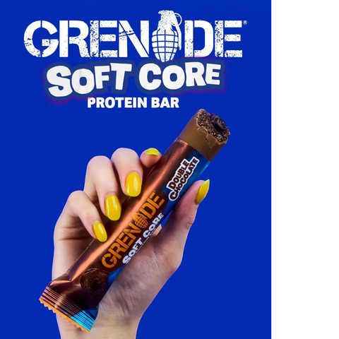 Guiltfree baton proteinowy Grenade Soft Core Double Chocolate trzymany w dłoni z żółtym manicure na niebieskim tle