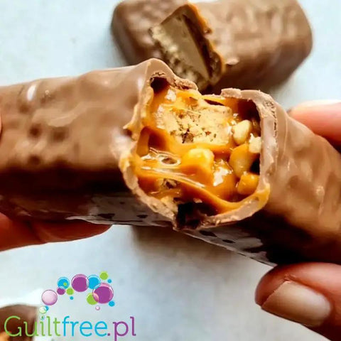 Guiltfree baton proteinowy Trec z karmelem, orzeszkami ziemnymi i mleczną czekoladą w przekroju