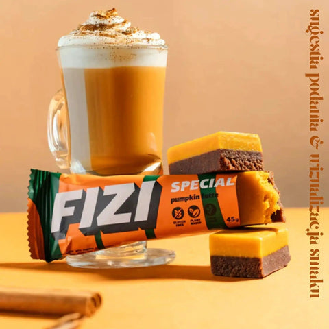 Wegański baton FIZI Special Pumpkin Latte marki Guiltfree z dynią i cynamonem obok kubka kawy latte.