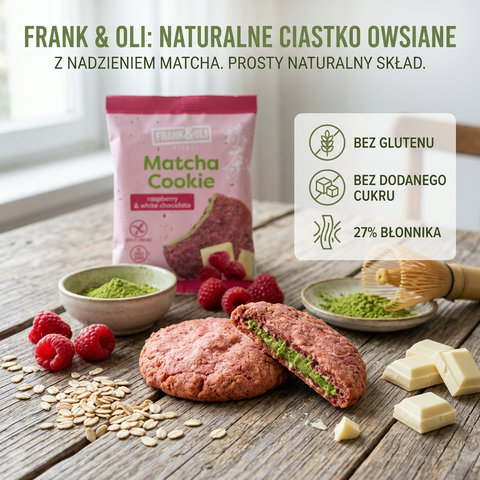 Guiltfree ciastko owsiane Frank & Oli z matchą, malinami i białą czekoladą na drewnianym stole z dodatkami