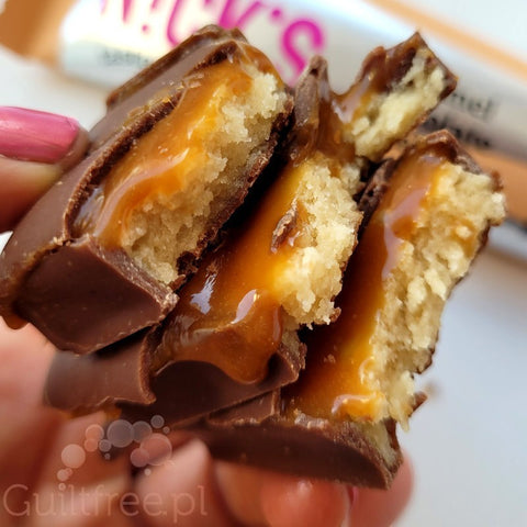 Baton proteinowy Guiltfree N!ck's Caramel w mlecznej czekoladzie z ciągnącym karmelem w zbliżeniu