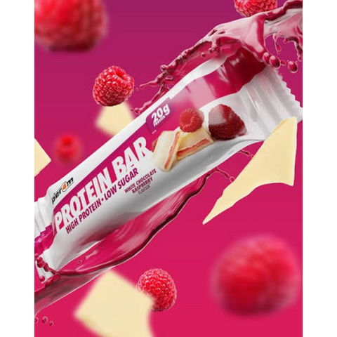 Baton proteinowy Guiltfree Per4m o smaku białej czekolady i malin z widocznym przekrojem, świeżymi owocami i czekoladą