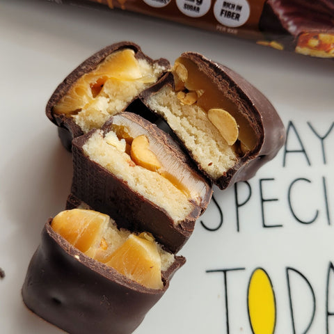 Guiltfree Quest Nutrition Peanutty Caramel protein bar pieces showing chocolate coating, caramel, and peanuts.