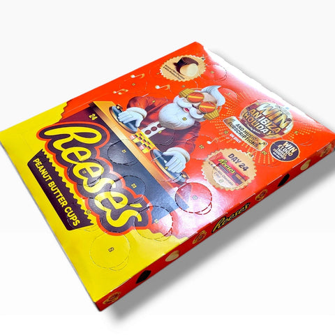 Kalendarz adwentowy Guiltfree Reese's 2026 z grafiką Mikołaja DJ-a, zawierający 24 okienka z czekoladkami z masłem orzechowym.