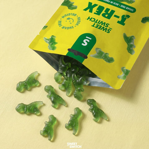 Wegańskie żelki bez cukru Sweet Switch T-Rex w kształcie zielonych dinozaurów o smaku jabłkowym wysypane z opakowania