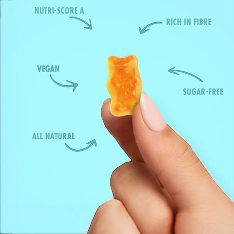 Dłoń trzymająca pomarańczowego żelka misia Sweet Switch Yummy Bears na jasnoniebieskim tle z opisami zalet produktu