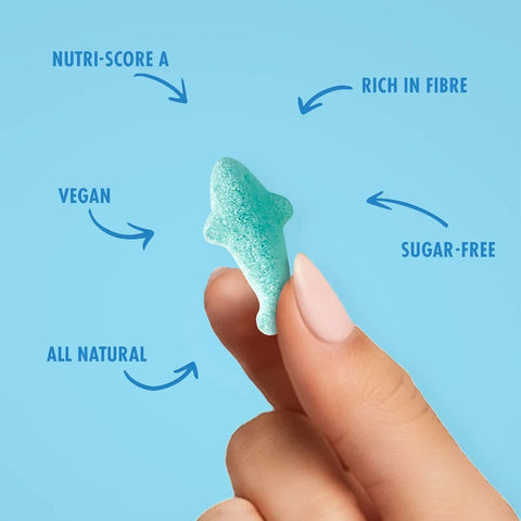 Dłoń trzymająca niebieskiego żelka w kształcie rekina Sweet Switch Baby Shark z Guiltfree, wegańska przekąska bez cukru.