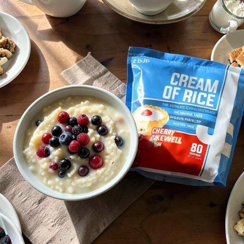 Miska kleiku ryżowego Guiltfree TBJP Cream of Rice o smaku Cherry Bakewell z owocami jagodowymi na stole