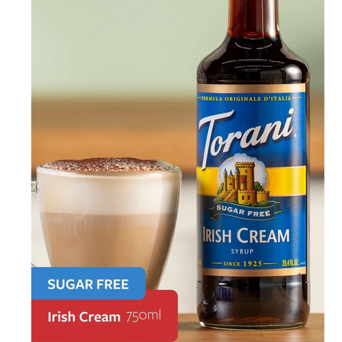 Guiltfree syrop do kawy Torani Irish Cream bez cukru w szklanej butelce obok filiżanki cappuccino