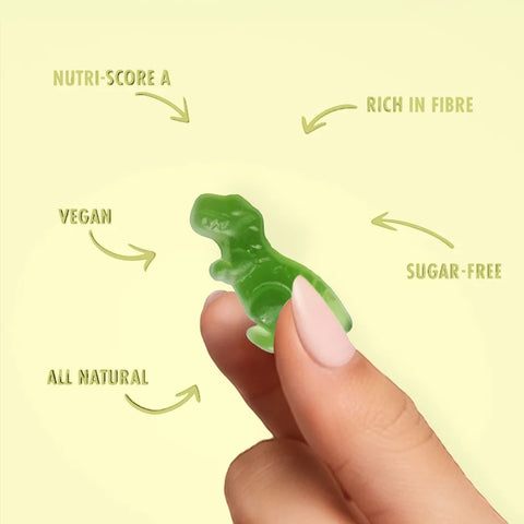 Dłoń trzymająca zielonego wegańskiego żelka w kształcie dinozaura Sweet Switch T-Rex z oferty Guiltfree